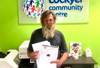 A flood-impacted man receiving donated vouchers. Image: Lockyer Community Centre