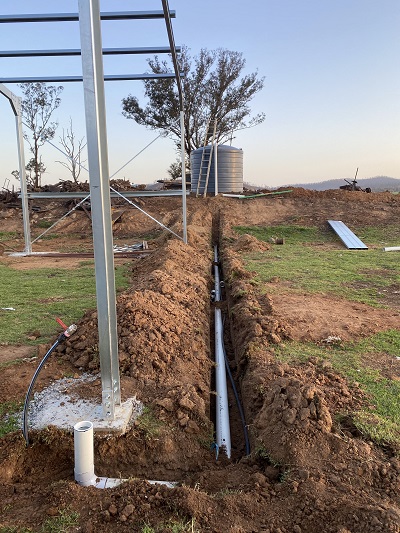 A partially built shed with a water tank behind it